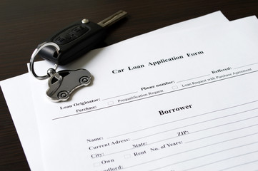 Car keys lying down on car application form.