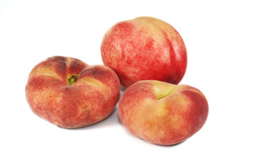 Nectarine and two flat peaches on white background