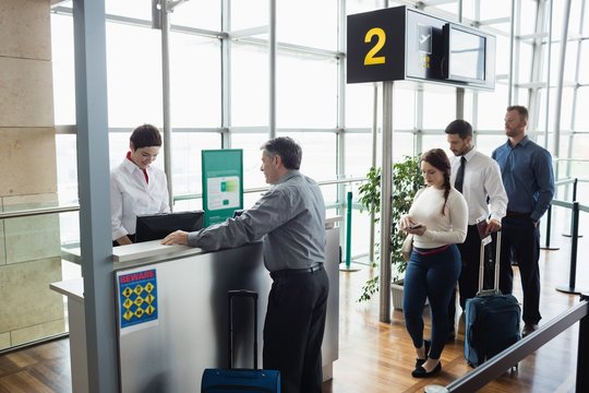 Passengers waiting in queue at check-in counter