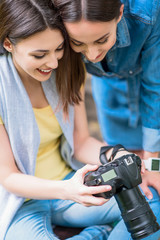 Happy female friends entertaining with photography