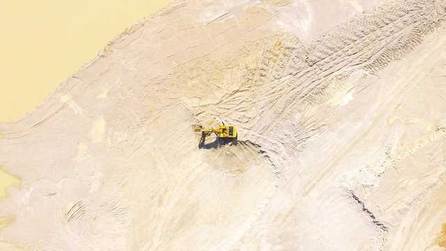 Camera flight over a working excavator in the mine. Industrial footage on mining theme. Heavy industry in Central Europe.