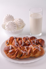 Food. A glass of milk, marshmallows and two rolls on a white background. In high key. 

Buns with raisins in frosting. Buns with a delicious crust. Baby food. Easy feed.