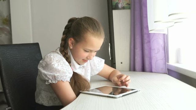 Schoolgirl uses a digital tablet computer at home
