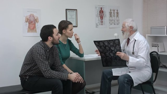 Healthcare and medical concept. Doctor with patients looking at x-ray.