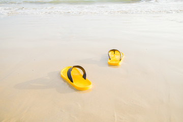 Obraz premium yellow sandals on the beach at the vacation or relax time