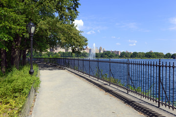 Central Park reservoir with fountain with Upper West Side skyline and blue sky with clouds, Manhattan, New York City