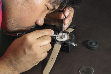 watchmaker try to repair watch with his tools