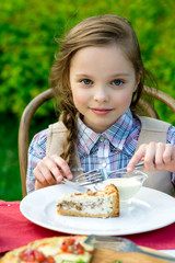 cute little girl sitting by dinner table and eating