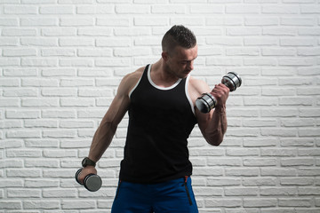 Young Man Exercise Biceps With Dumbbells