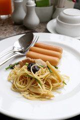 Puff yellow noodles with chicken meat and pork sausage on white