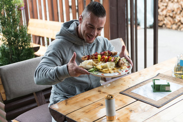 Man Eating Chicken With Rice In Outdoor Restaurant