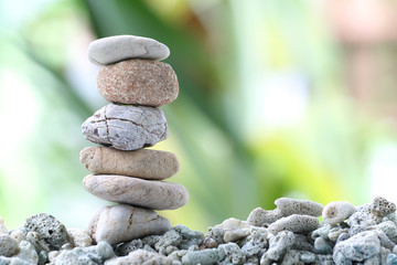 Balance stone on pile rock with garden background.