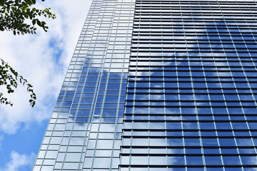 Clouds and blue sky reflection in building windows.