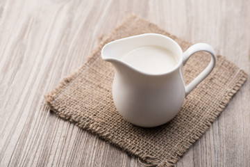 Fototapeta na wymiar Milk in jug on wood table