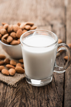 Almond milk in glass with almonds