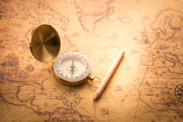 Compass and pencil on old map vintage style