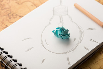 Inspiration concept crumpled paper with light bulb metaphor for