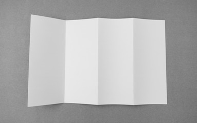 Four - fold white template paper on gray  background .