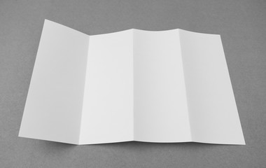 Four - fold white template paper on gray  background .