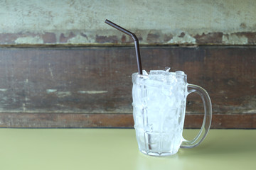 Glass of drink with ice placed on table.