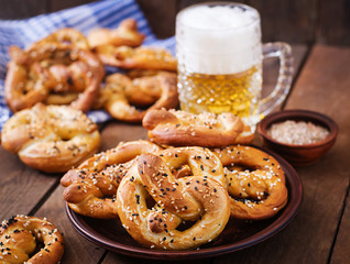Oktoberfest salted soft pretzels in a bowl and beer from Germany on wooden background.