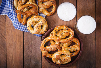 Oktoberfest salted soft pretzels in a bowl and beer from Germany on wooden background. Top view