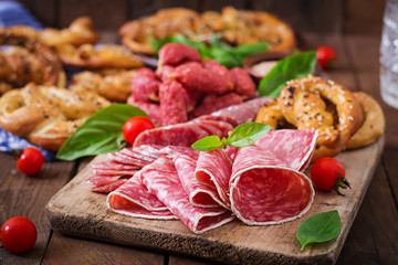 Pretzels and various sausages on wooden background. Oktoberfest.