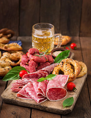 Glass of beer, pretzels and various sausages on wooden background. Oktoberfest.