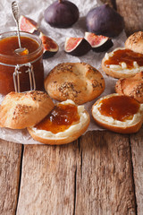 Glass jar with some fig jam and sweet buns close-up. Vertical
