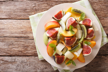 Healthy Fruit salad with fig, peach, melon, kiwi and orange. Horizontal top view
