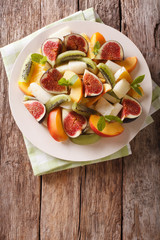 Healthy Fruit salad with fig, peach, melon, kiwi and orange close-up. vertical top view
