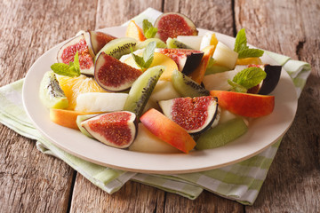 Salad of ripe fruit: figs, peaches, melons, kiwi and orange close-up. horizontal
