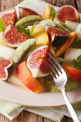 Assorted fruits fig, peach, melon, kiwi and orange close-up. vertical
