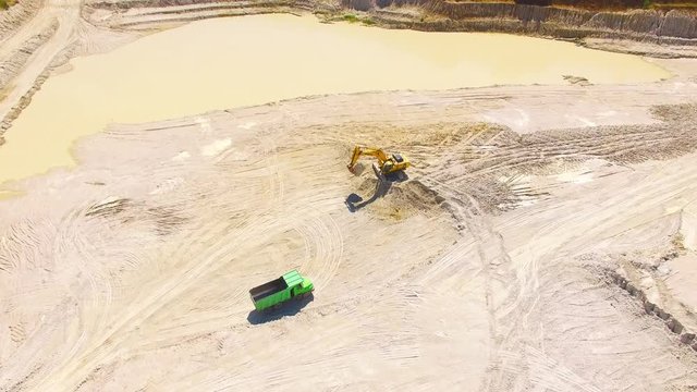 Camera flight over a working excavator in the mine. Industrial footage on mining theme. Heavy industry in Central Europe.