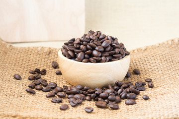 Coffee beans in wood spoon and on old wood table