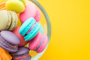 Fototapeta na wymiar Colorful france macarons on yellow background - Vintage filter effect
