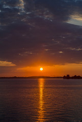 Naklejka premium Orange sunset over a european lake, blue clouds sky