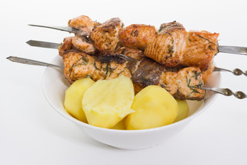 potatoes with salmon on a spit on a white background