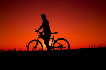 Obraz na płótnie Canvas sunset and silhouette backlight bikers