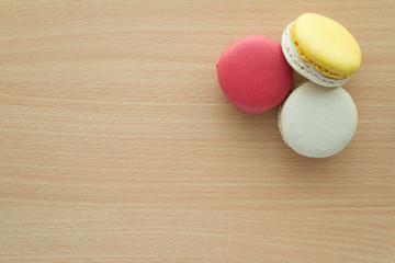Colorful france macarons on wooden desk background.