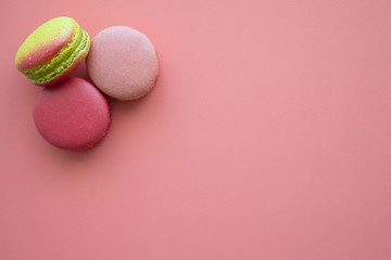 Colorful france macarons on pink background.