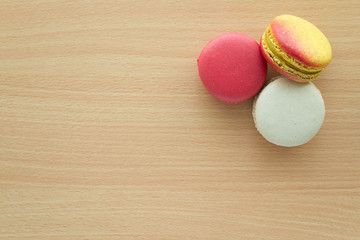 Colorful france macarons on wooden table background.
