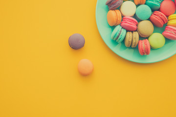 Colorful france macarons on yellow background