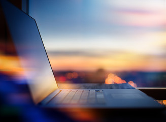 Blurred background : laptop on city night light background.