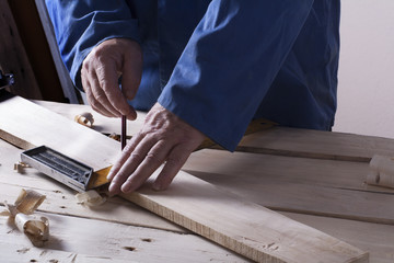 Carpenter working with plane on wooden background at Building Site. Joiner workplace