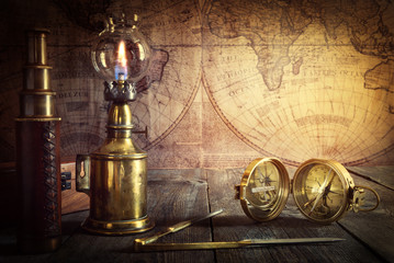 Fototapeta na wymiar Ship lamp, compass, divider and spyglass on the wood table. Travel and nautical theme grunge background. Retro style.
