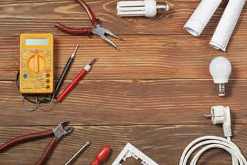Set of electrical tool on wooden background. Accessories for engineering work, energy concept.