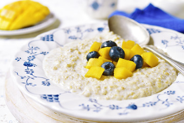 Oat porridge with mango and blueberry for a breakfast.