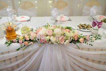 Beautiful wedding restaurant for marriage. White decor for bride and groom. Colorful decoration for celebration. Beauty bridal interior. Bouquet, food and flowers in hall