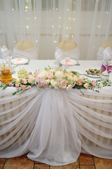 Beautiful wedding restaurant for marriage. White decor for bride and groom. Colorful decoration for celebration. Beauty bridal interior. Bouquet, food and flowers in hall
